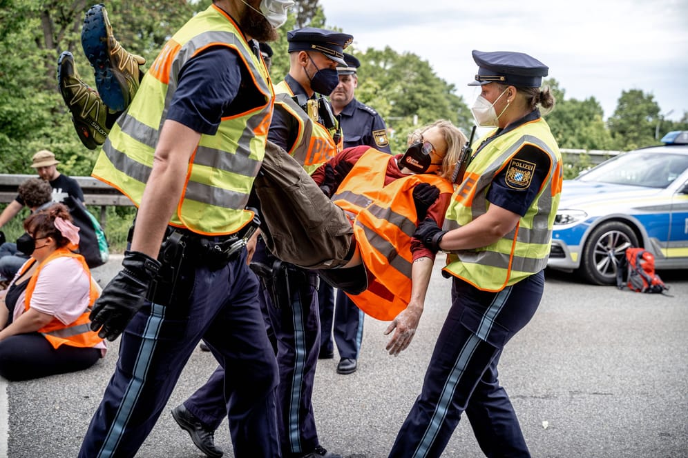 München (Archivbild): Polizisten tragen Aktivisten der "Letzten Generation" nach einer Blockade von der Straße.