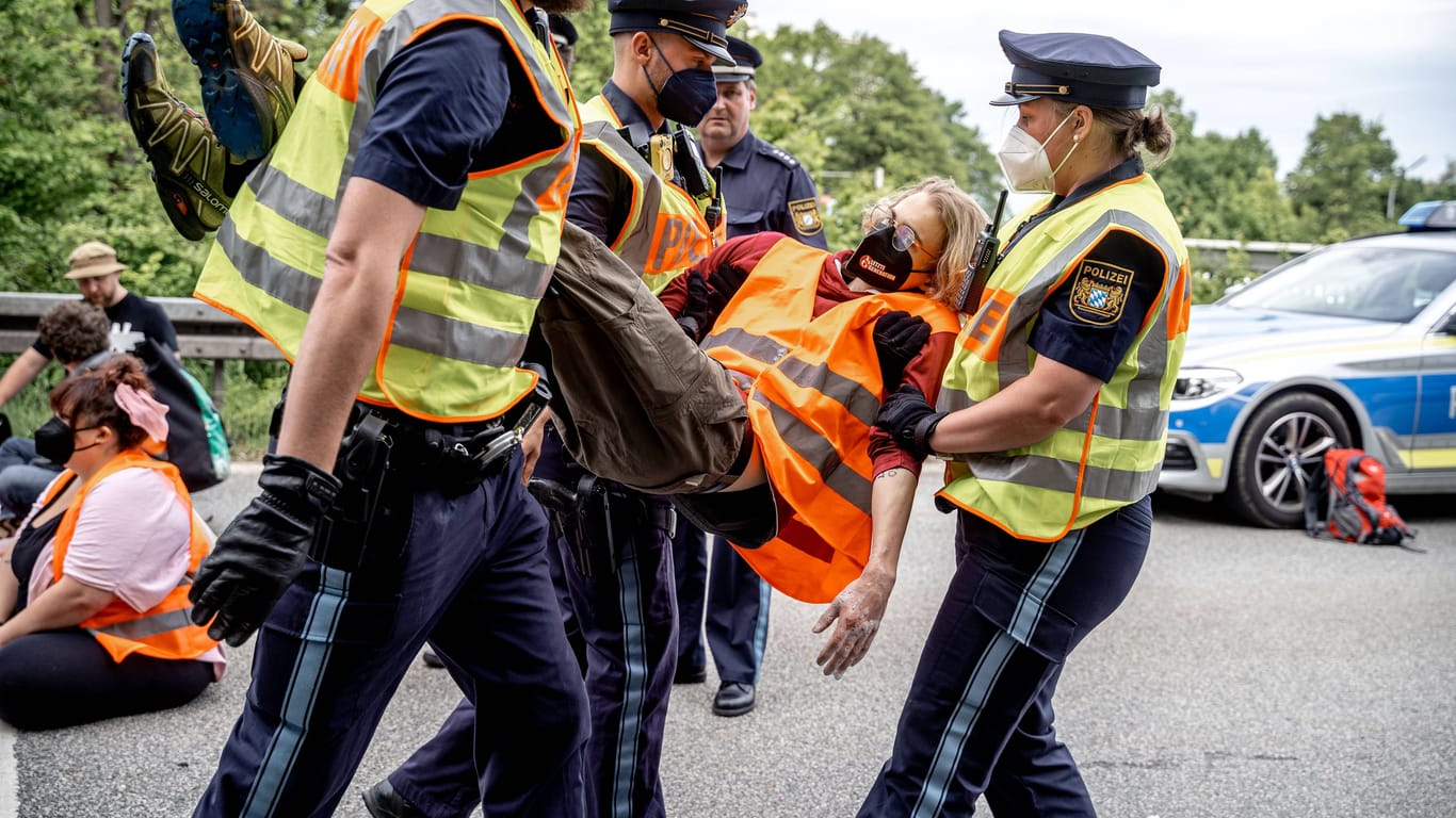Münchner Einsatzkräfte tragen Aktivisten der "Letzten Generation" nach einer Blockade von der Straße. (Archivbild)