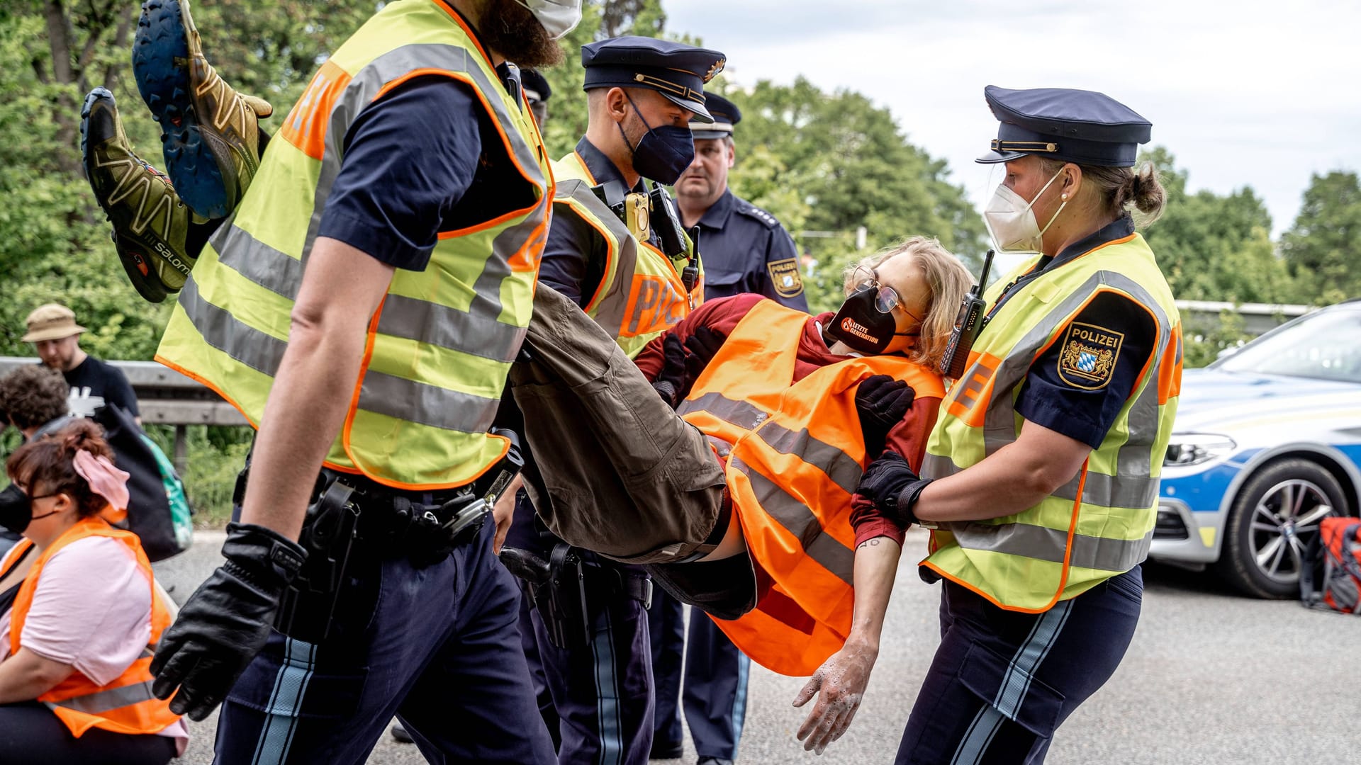 Münchner Einsatzkräfte tragen Aktivisten der "Letzten Generation" nach einer Blockade von der Straße. (Archivbild)