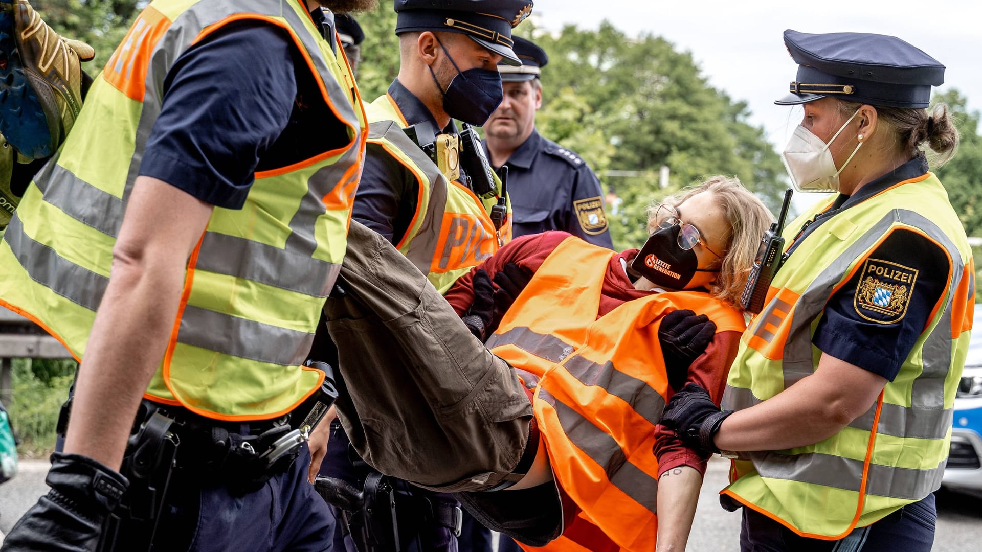 Münchner Einsatzkräfte tragen Aktivisten der "Letzten Generation" nach einer Blockade von der Straße. (Archivbild)