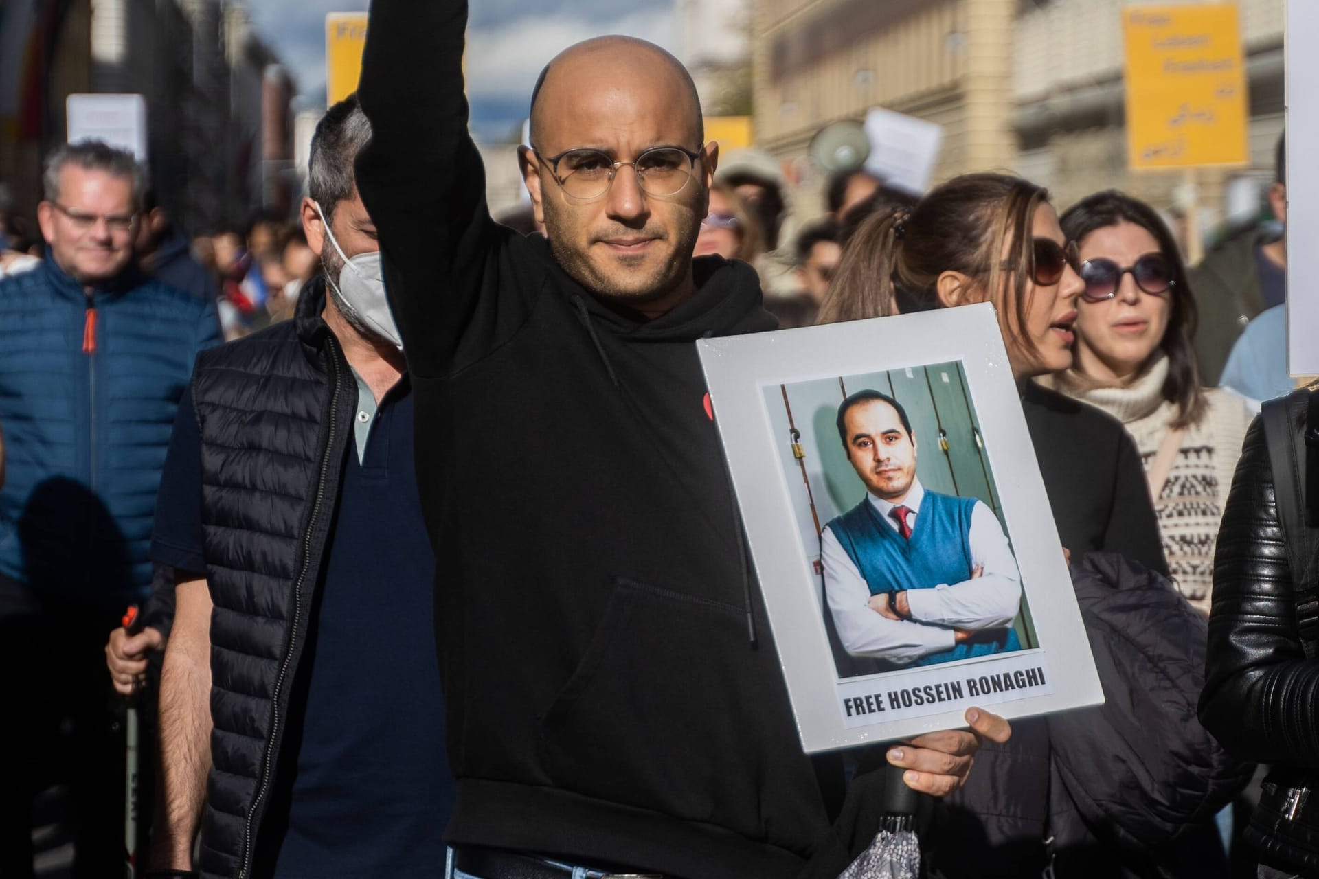 Protest für Mahsa Amini in München: Ein Teilnehmer trägt ein Schild mit der Aufschrift "Befreit Hossein Ronaghi".