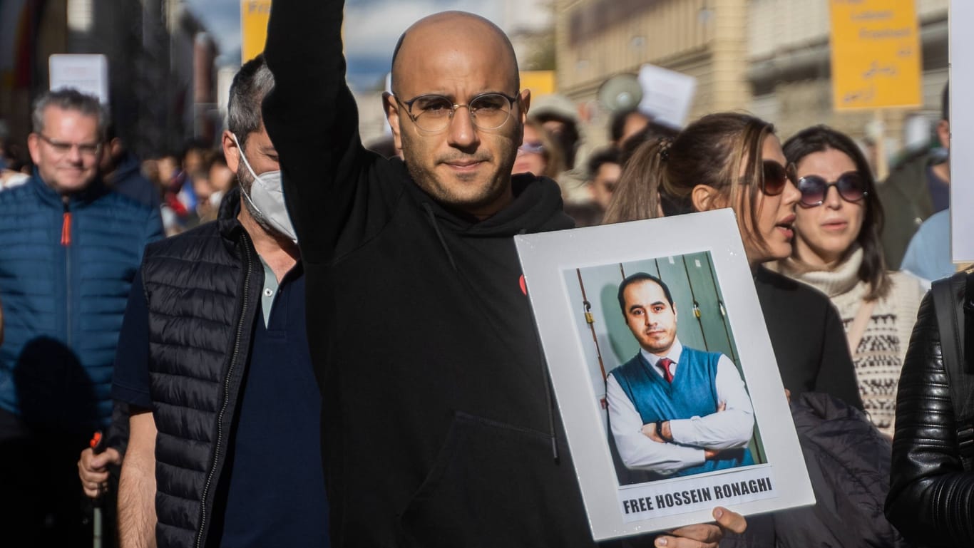 Protest für Mahsa Amini in München: Ein Teilnehmer trägt ein Schild mit der Aufschrift "Befreit Hossein Ronaghi".