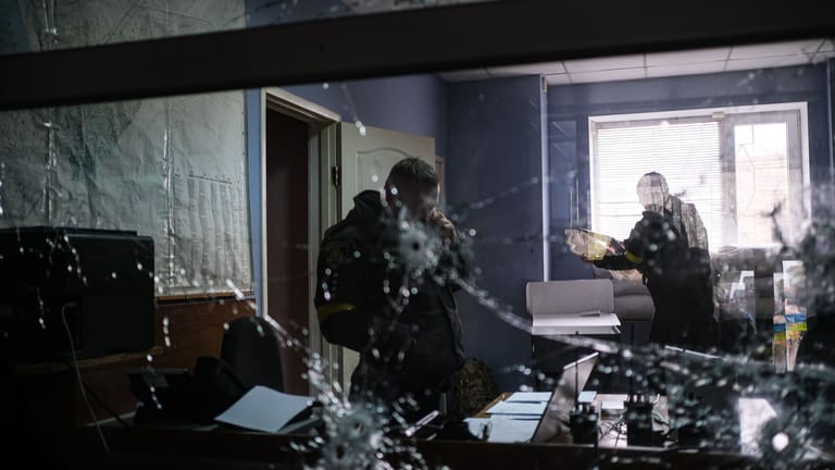 Polizeistation in Cherson: Drinnen ist die Glasscheibe mit Kugeln durchsiebt, draußen jagt die Polizei frei gelassene Kriminelle.