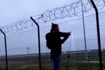 Ein Klimaaktivist durchtrennt einen Zaun am BER: Der Flugbetrieb des Airports musste vorübergehend eingestellt werden.