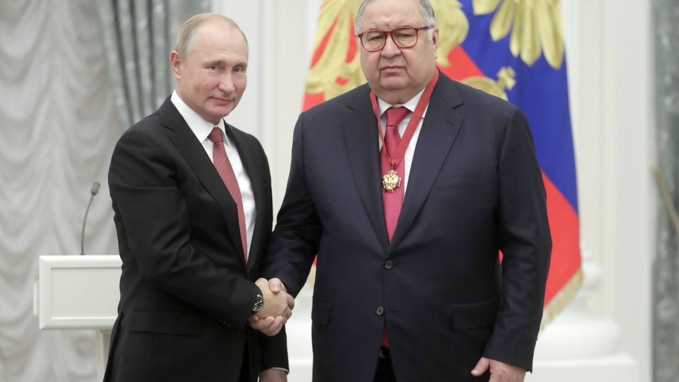 Der russische Oligarch Alisher Usmanov schüttel die Hand von Wladimir Putin (Archivbild): Wegen der Nähe zum Kreml wurden seine Besitztümer in der EU eingefroren.