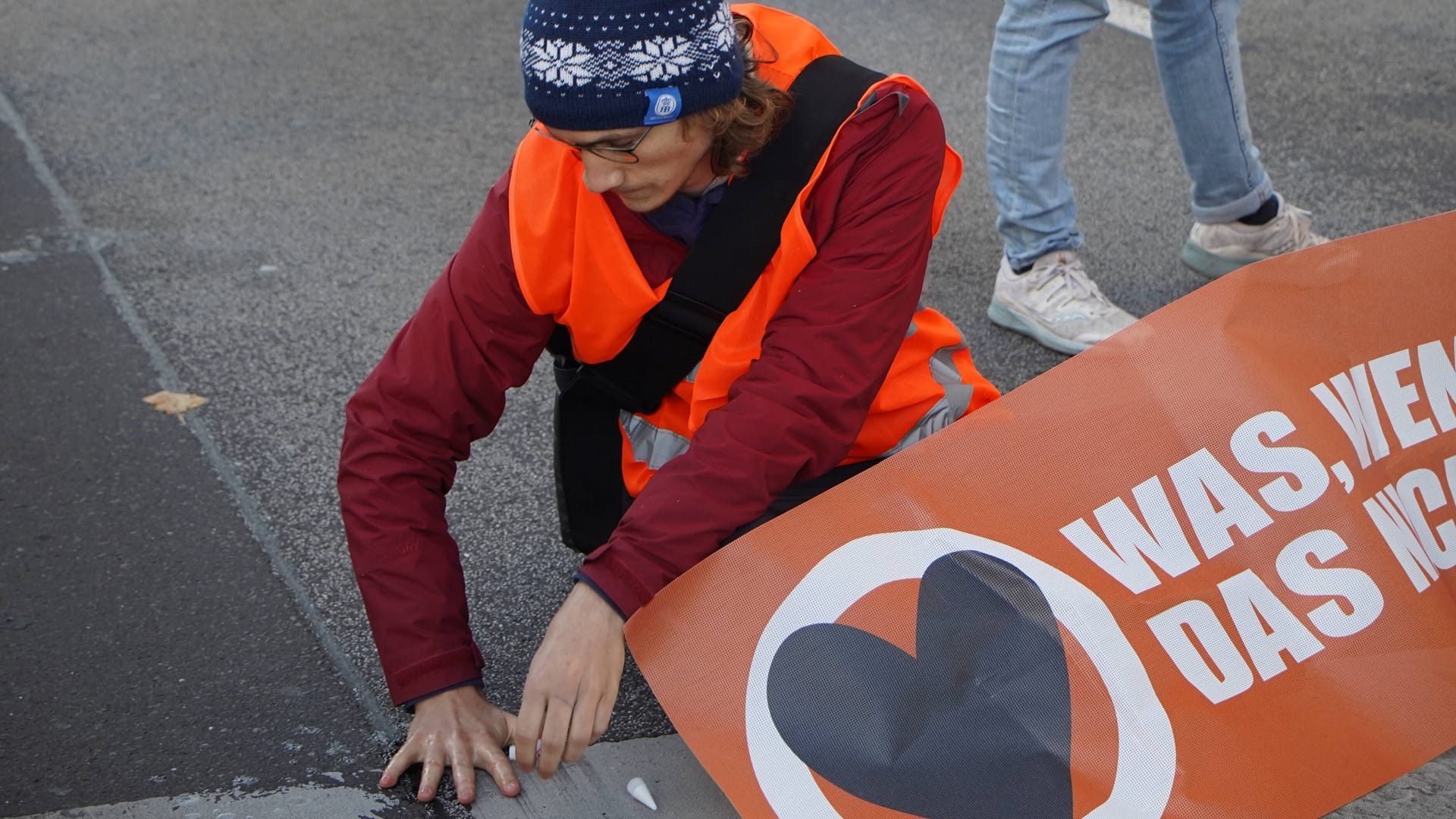 Ein festgeklebter Klimaaktivist auf einer Berliner Straße (Archivbild): Einem Bericht zufolge führt die Polizei viele von ihnen als Mehrfachtäter.