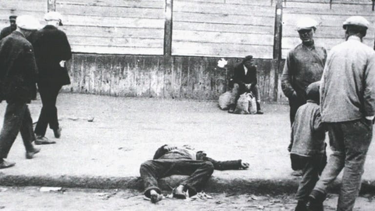 Ein Mensch, der verhungert ist, liegt leblos auf der Straße: Stalin ließ damals im Zuge der Zwangskollektivierung auf dem Land massenhaft Nahrung konfiszieren.