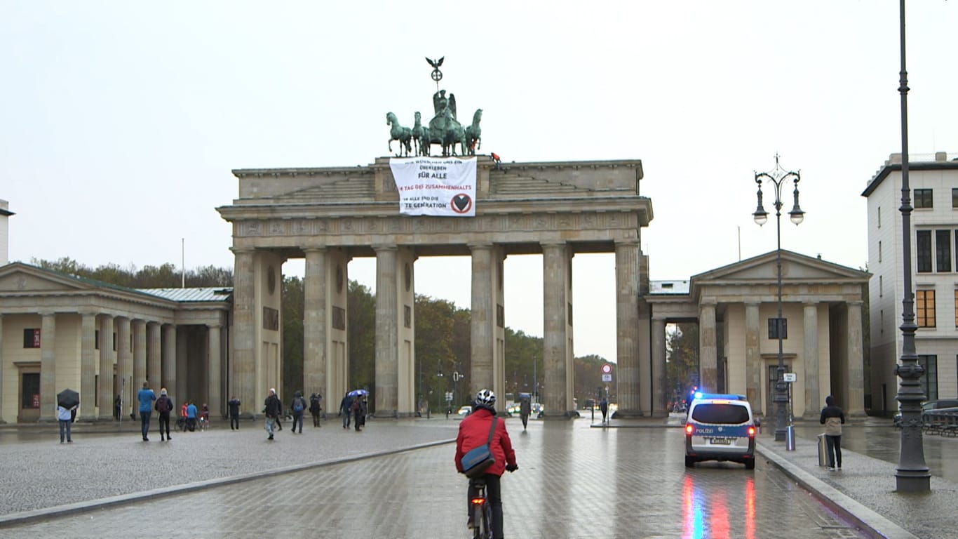 Das Brandenburger Tor in Berlin: Aktivisten haben hier ein Plakat in großer Höhe aufgehängt.