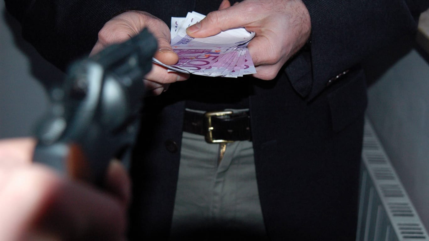 Bewaffneter Räuber fordert Geld (Symbolbild).