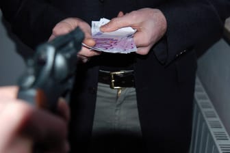 Bewaffneter Räuber fordert Geld (Symbolbild).