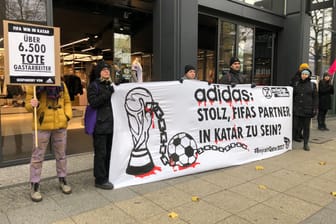 Aktivisten mit einem Banner vor dem Laden: Der Sponsor Adidas wird kritisiert.