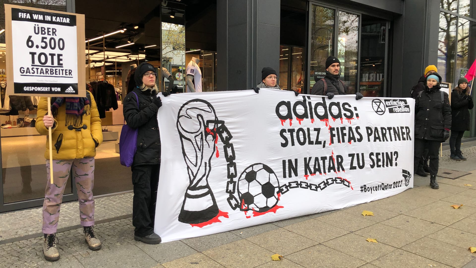 Aktivisten mit einem Banner vor dem Laden: Der Sponsor Adidas wird kritisiert.