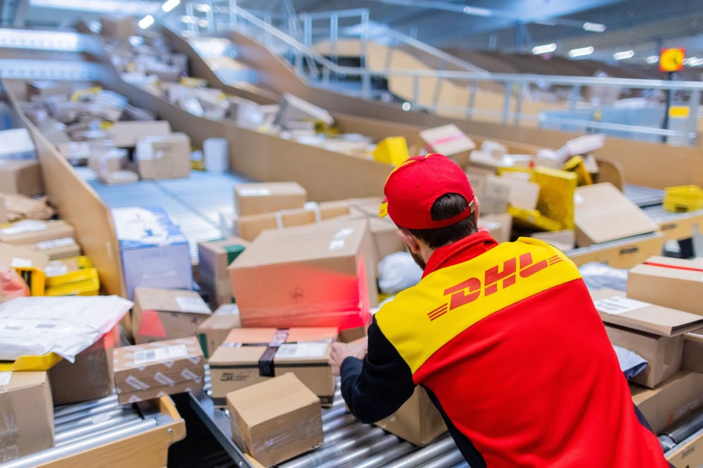 Ein Zusteller sortiert Pakete (Symbolbild): Im diesjährigen Weihnachtsgeschäft rechnet die Deutsche Post wieder mit Paketmassen.