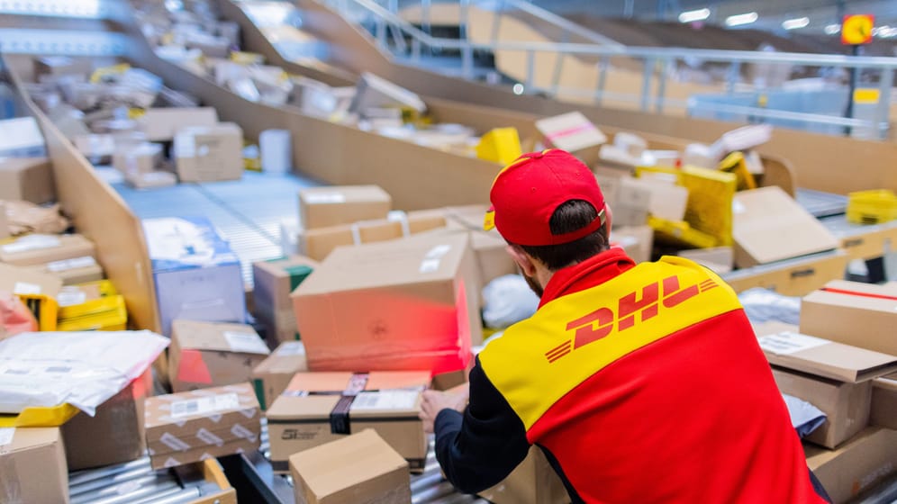 Ein Zusteller sortiert Pakete (Symbolbild): Im diesjährigen Weihnachtsgeschäft rechnet die Deutsche Post wieder mit Paketmassen.