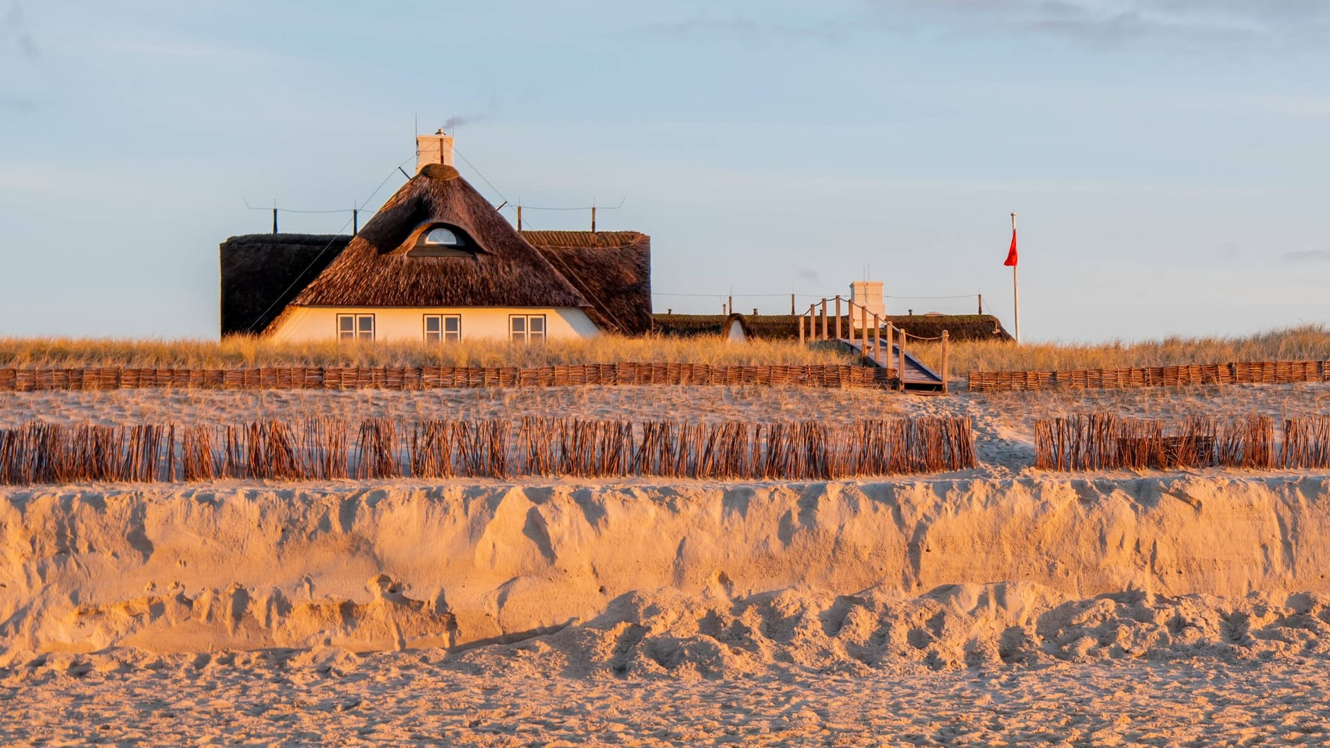 Ein Reetdachhaus hinter den Dünen auf Sylt (Symbolbild): Was steckt hinter den Baggerarbeiten?