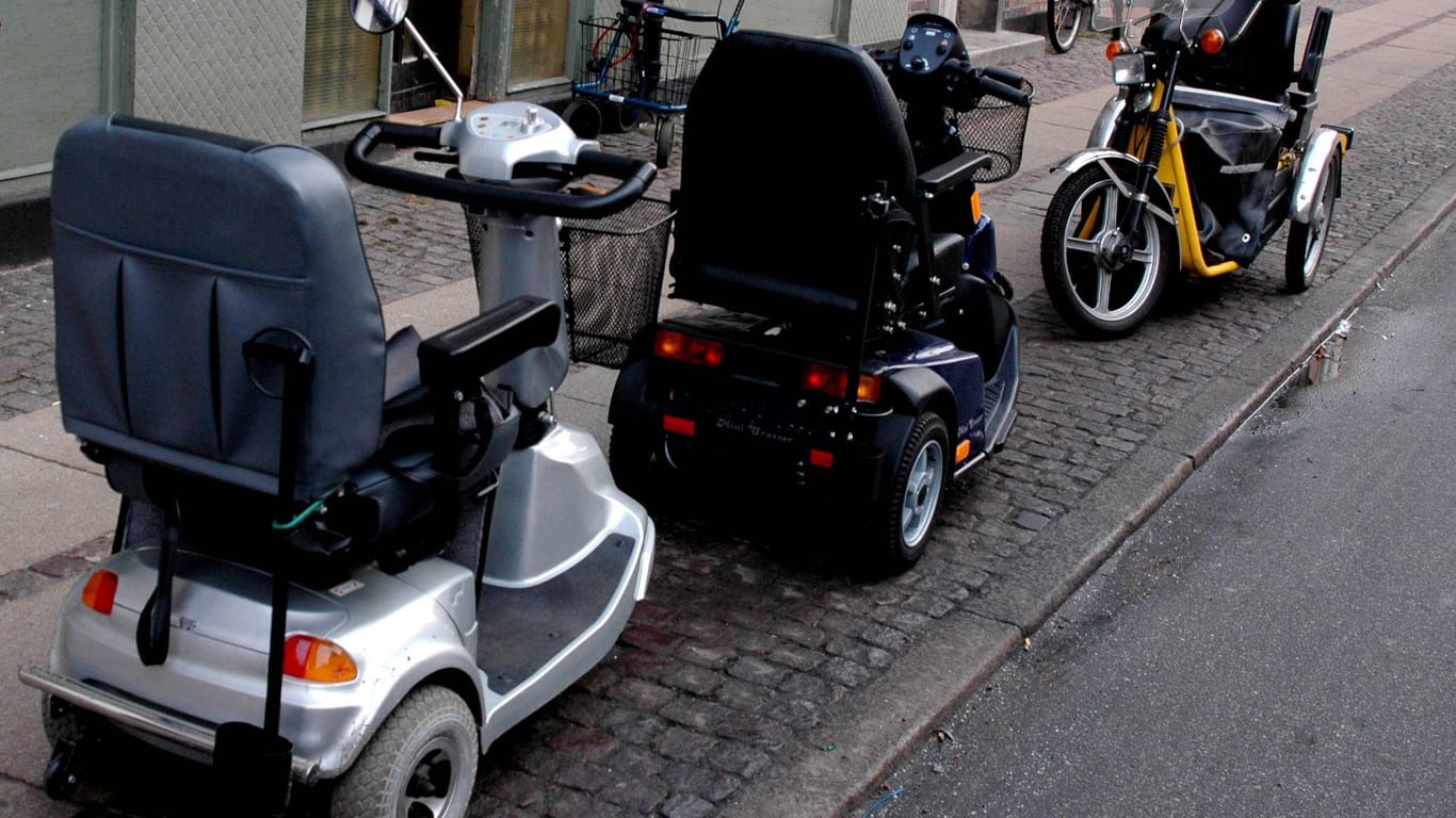 Elektrische Rollstühle parken auf dem Bürgersteig.