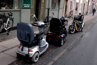 Elektrische Rollstühle parken auf dem Bürgersteig.