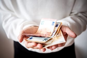 Eine Frau hält Geldscheine (Symbolbild): Die Zinswende eröffnet Sparern wieder mehr Optionen.