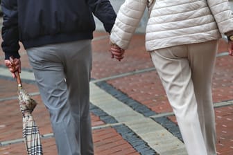 Ein älteres Paar läuft Hand in Hand (Symbolbild): Nach einer Scheidung werden die Rentenansprüche untereinander aufgeteilt.