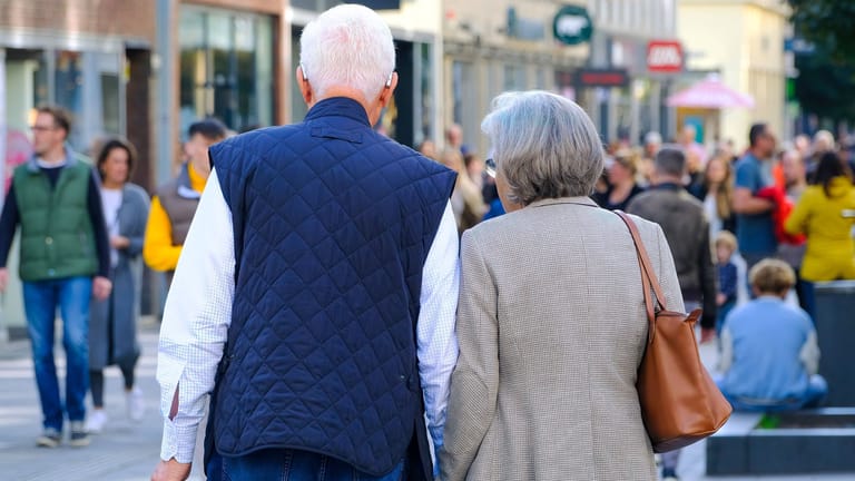 Senior und Seniorin in einer Einkaufsstraße (Archivbild): Viele Deutsche gehen früher in Rente.
