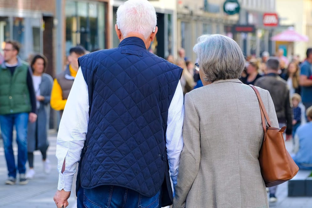 Senior und Seniorin in einer Einkaufsstraße (Archivbild): Viele Deutsche gehen früher in Rente.