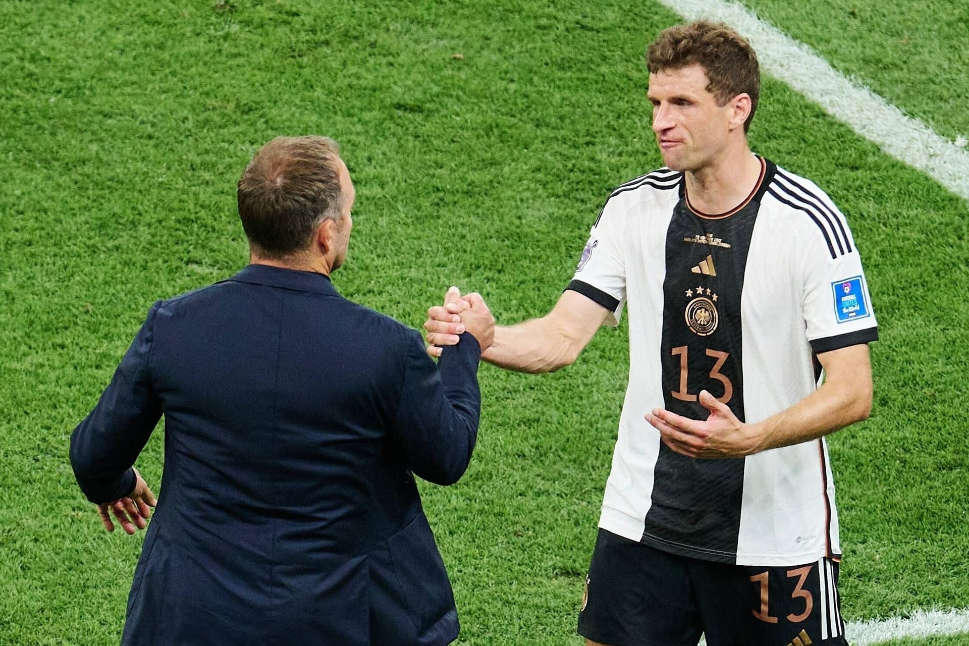 Hansi Flick und Thomas Müller auf dem Spielfeld.