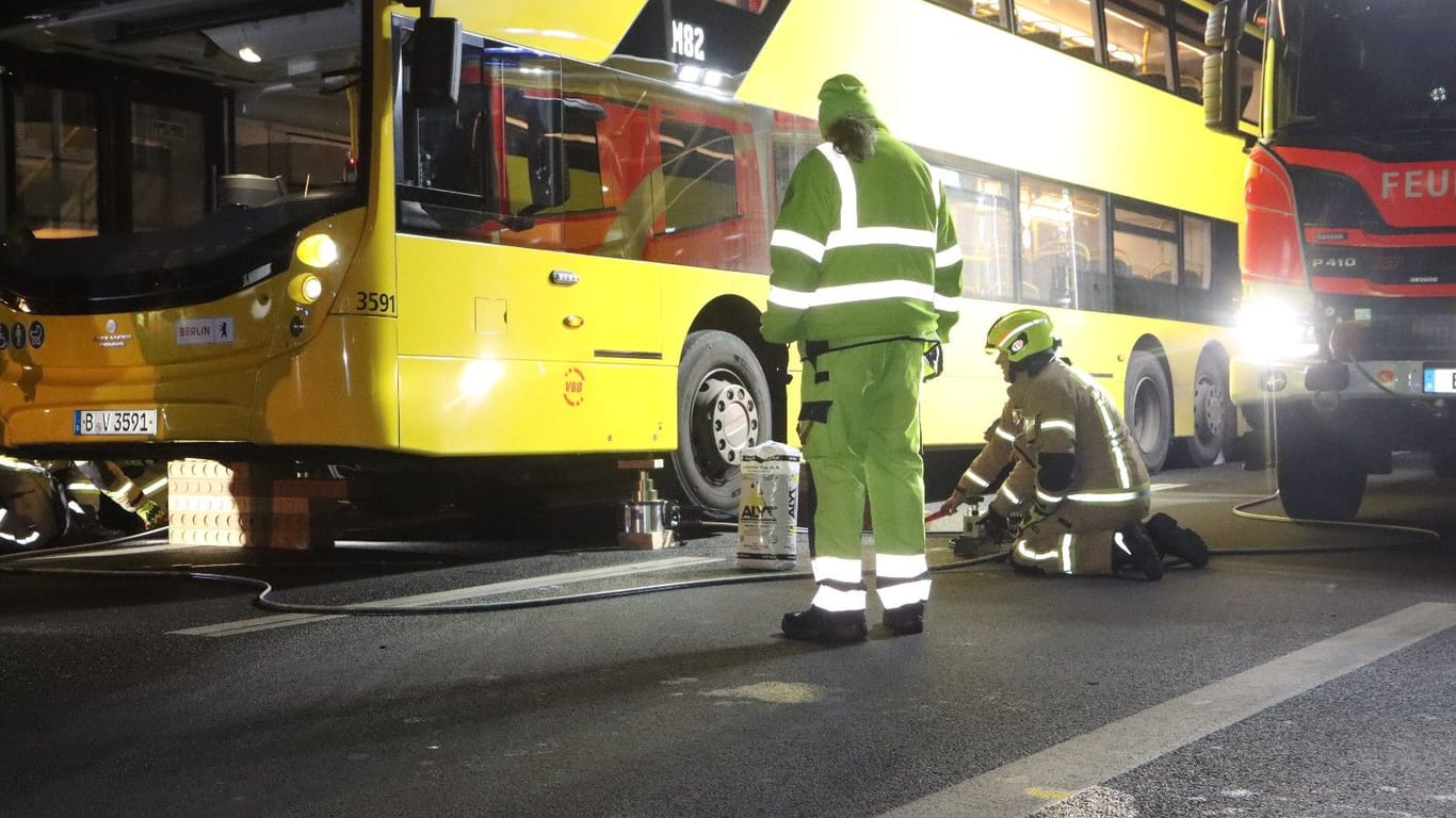 Feuerwehrleute am Unfallort: Die Jugendlichen wurden unter dem Bus eingeklemmt, das Fahrzeug musste mit schwerem Gerät angehoben werden.