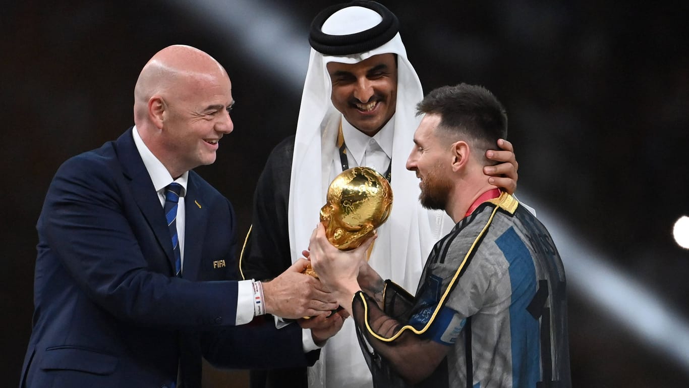 Lionel Messi: Der argentinische Superstar bekam vom katarischen Emir ein arabisches Gewand umgelegt – und von Fifa-Präsident Infantino den Pokal in die Hand gedrückt.