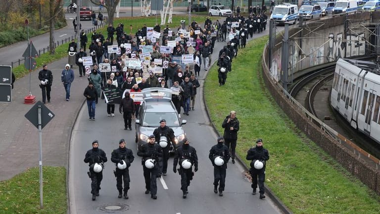 Köln: Pro-russische Demonstranten, die sich gegen Waffenlieferungen in die Ukraine aussprechen, ziehen in Begleitung von Polizisten durch die Stadt.