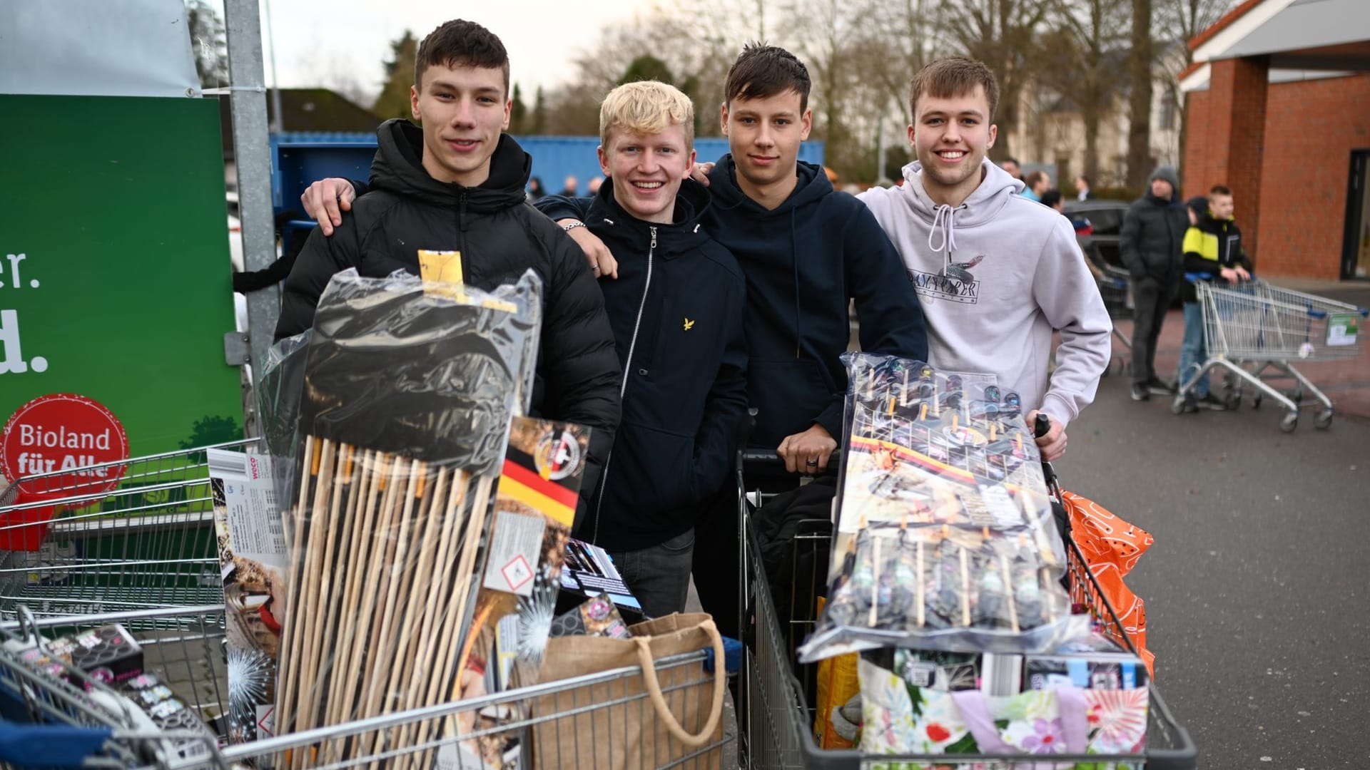 Vier junge Niederländer zeigen ihre Ausbeute. Tausende Landsleute decken sich mit Raketen und Knallern ein.