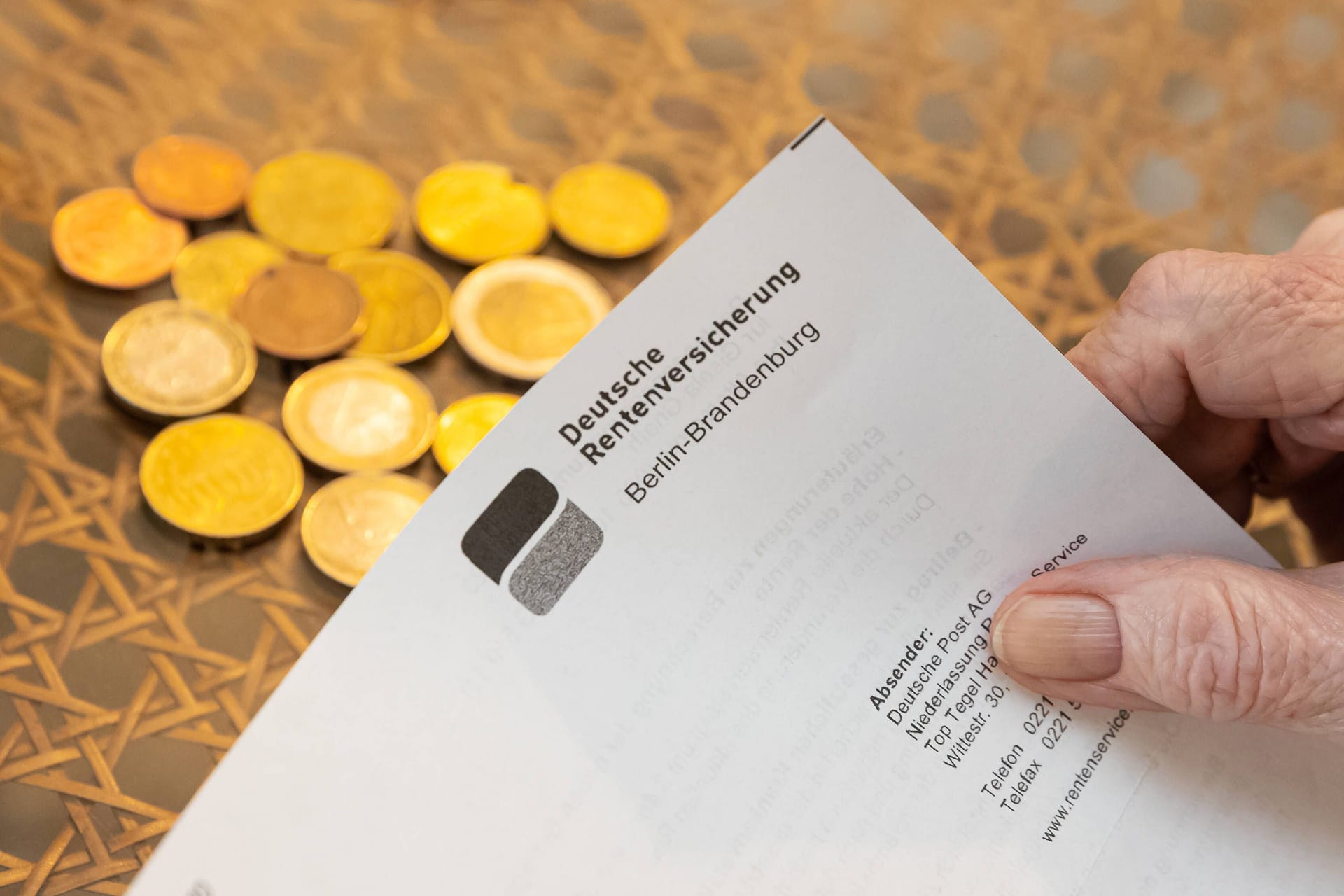 Seniorin hält einen Rentenbescheid (Symbolbild): Für ehemalige DDR-Bürger gelten beim Versorgungsausgleich andere Regeln.