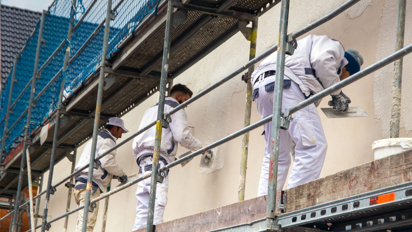Maler beim Verputzen der Außenfassade: Jedes zweite Unternehmen ist durch den Fachkräftemangel gehemmt.