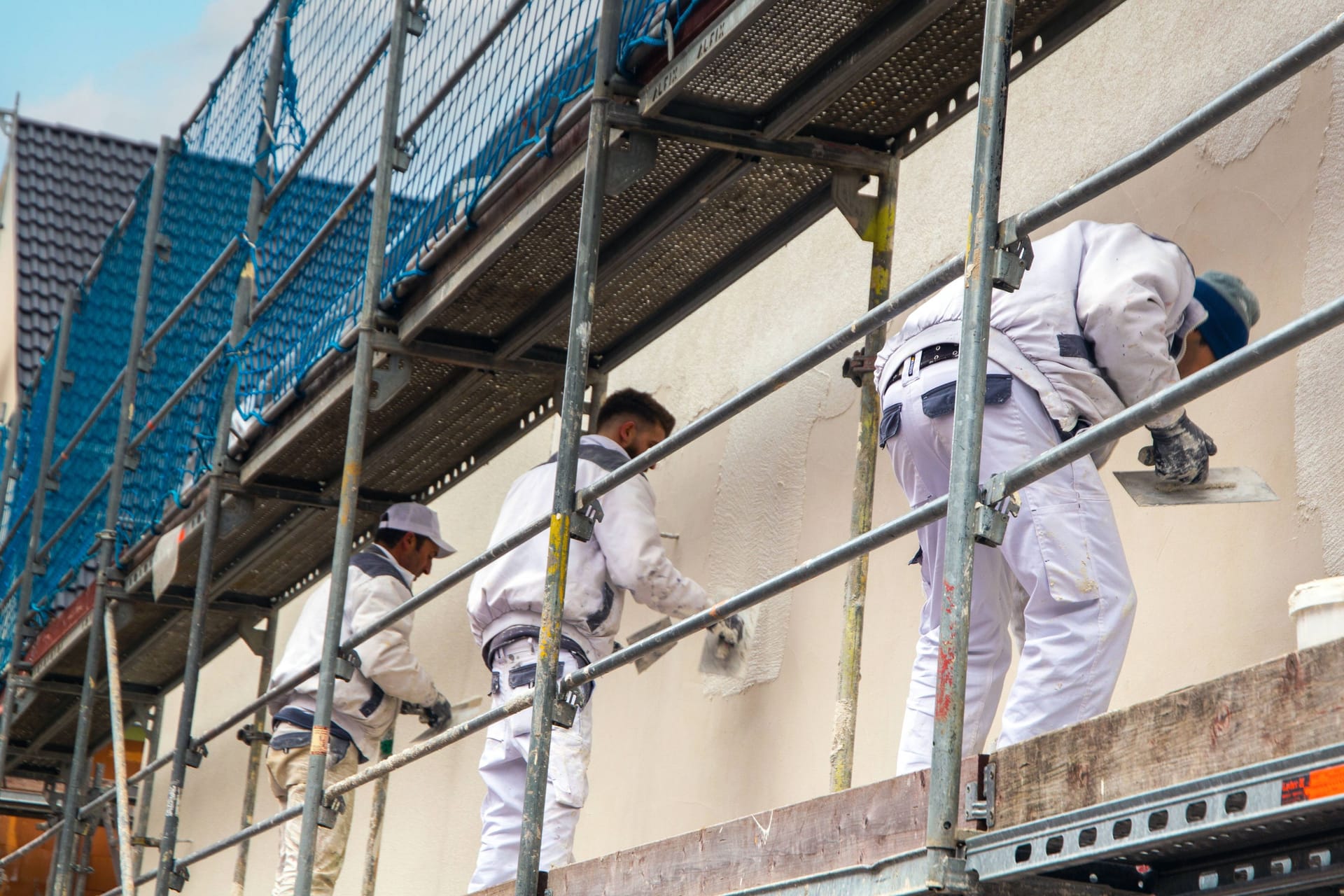 Maler beim Verputzen der Außenfassade: Jedes zweite Unternehmen ist durch den Fachkräftemangel gehemmt. Maler beim Verputzen der Außenfassade: Jedes zweite Unternehmen ist durch den Fachkräftemangel gehemmt.