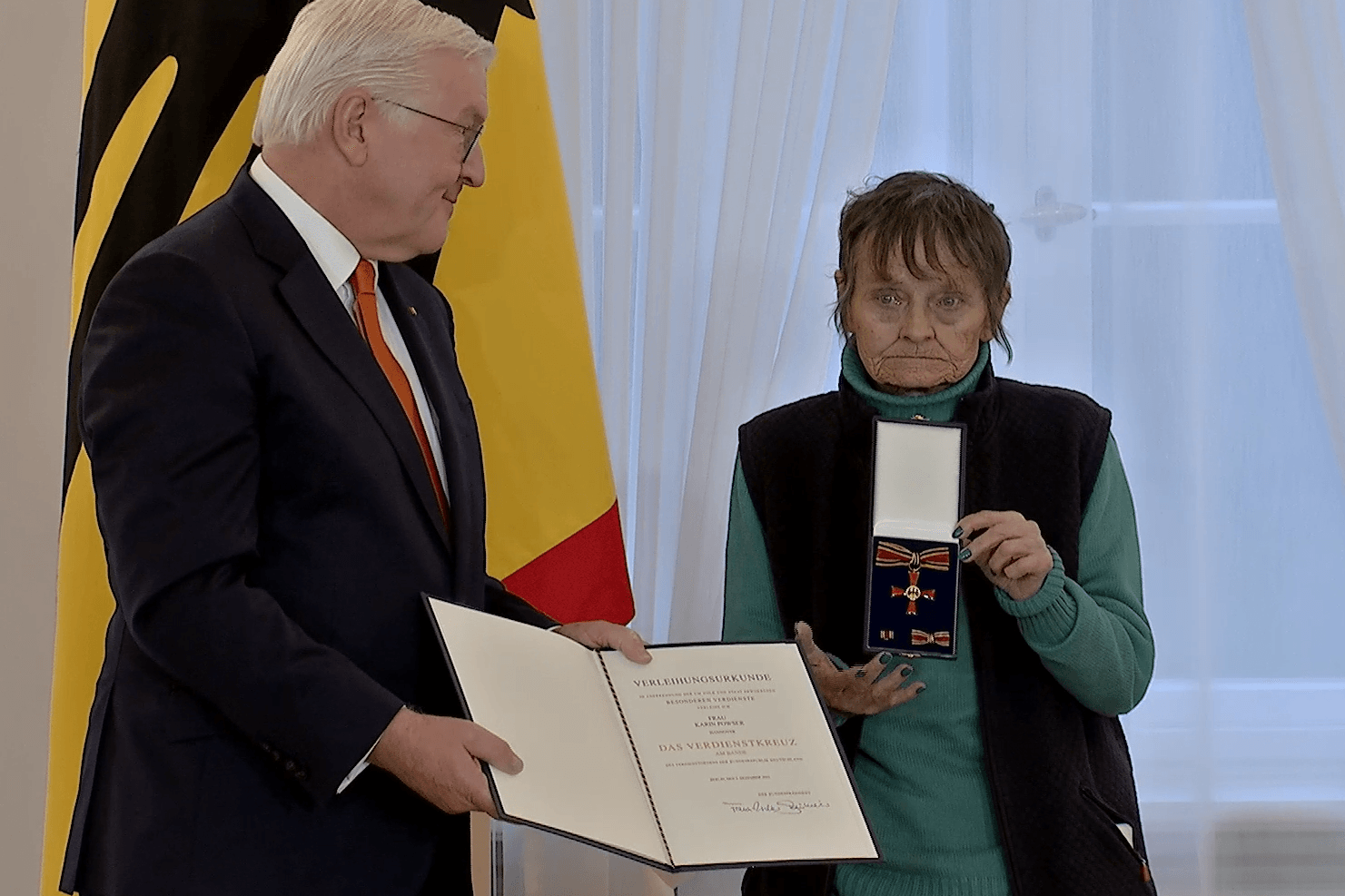 Ehrung für eine ehemalige Obdachlose aus Hannover (Screenshot): Bundespräsident Frank-Walter Steinmeier zeichnet Dokumentarfotografin Karin Powser aus.