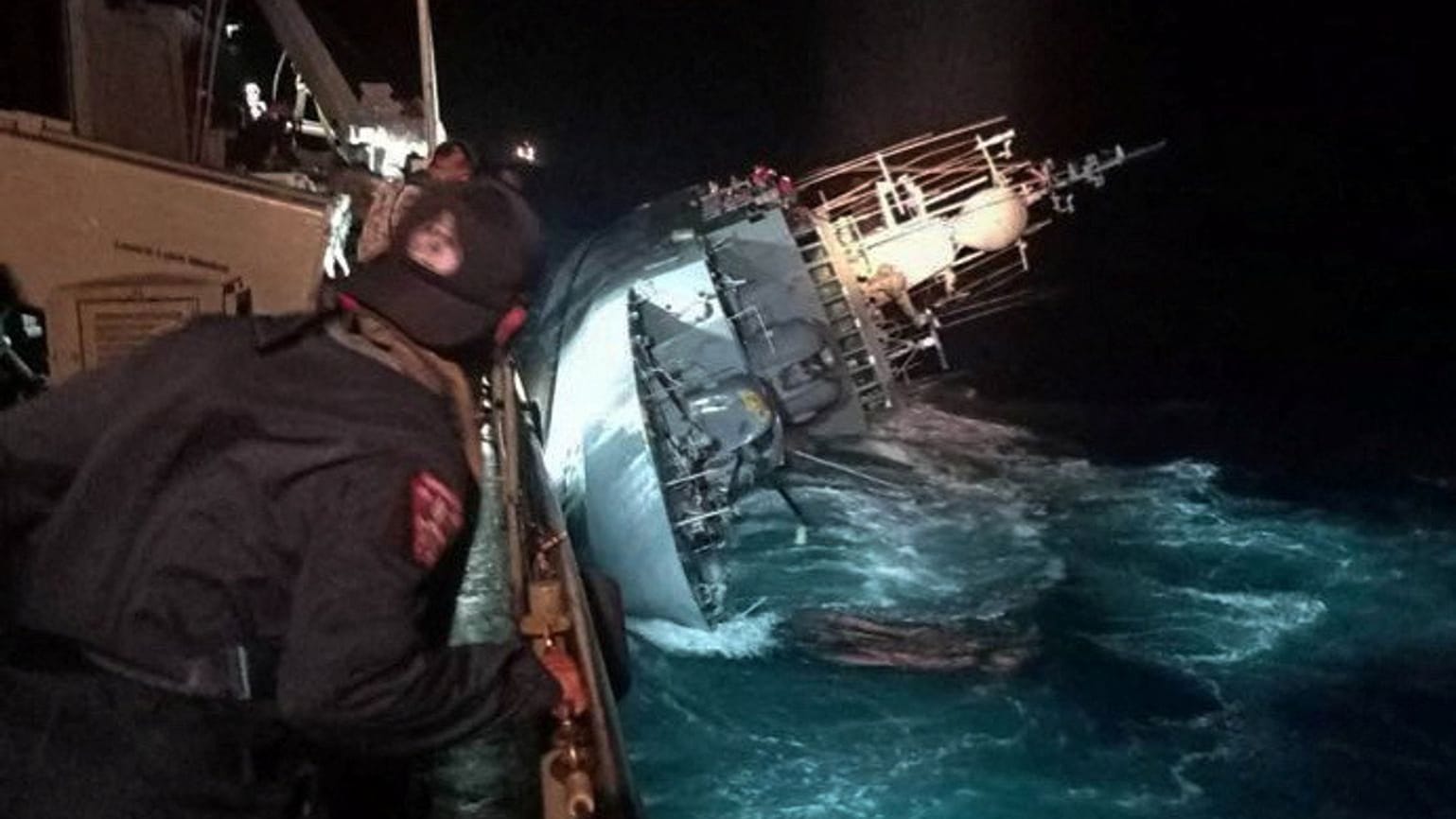 A marine looks at the capsized HTMS Sukhothai warship in the Gulf of Thailand A marine looks at the capsized HTMS Sukhothai warship in the Gulf of Thailand