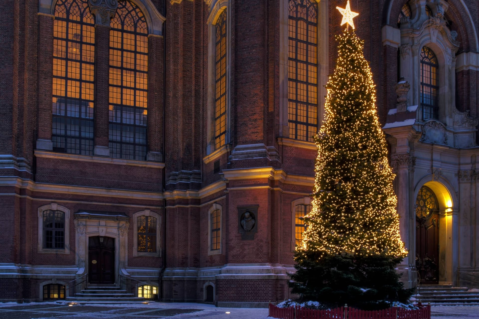 Ein beleuchteter Weihnachtsbaum steht vor einer Kirche (Symbolbild): In den nächsten Tagen wird es wohl keinen Schnee mehr geben.