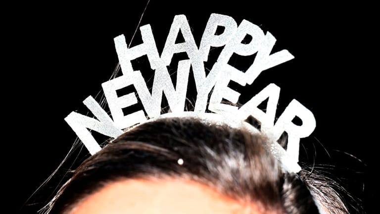 Frau mit "Happy new year"-Haarreif: Der Neujahrstag bleibt ebenfalls mild.