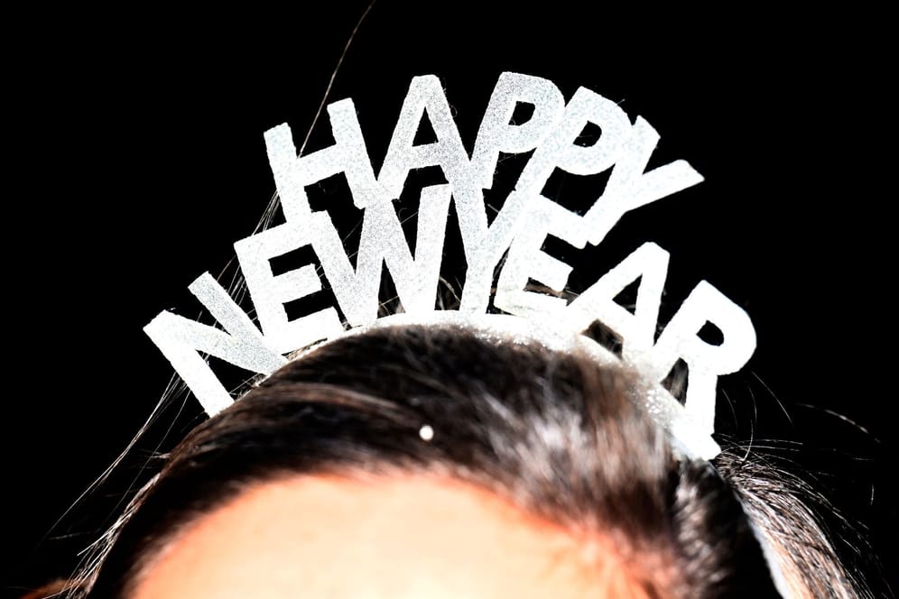 Frau mit "Happy new year"-Haarreif: Der Neujahrstag bleibt ebenfalls mild.