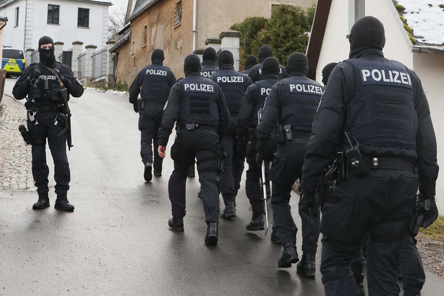 Einsatzkräfte der Polizei laufen zum Jagdschloss Waidmannsheil, das im Rahmen der Razzia durchsucht wurde.