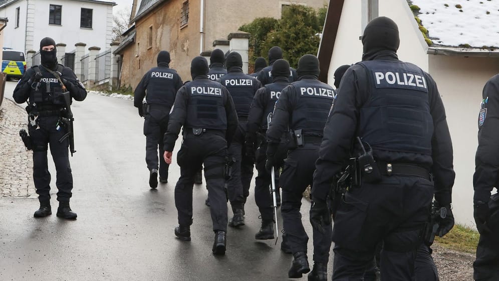 Einsatzkräfte der Polizei laufen zum Jagdschloss Waidmannsheil, das im Rahmen der Razzia durchsucht wurde.