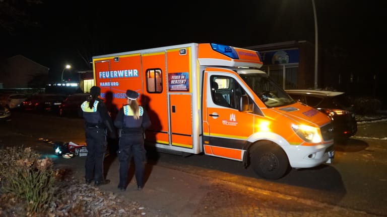 Polizisten stehen vor einem Rettungswagen am Tatort: Ob die Frau in den Angriff überlebt hat, ist noch unklar.