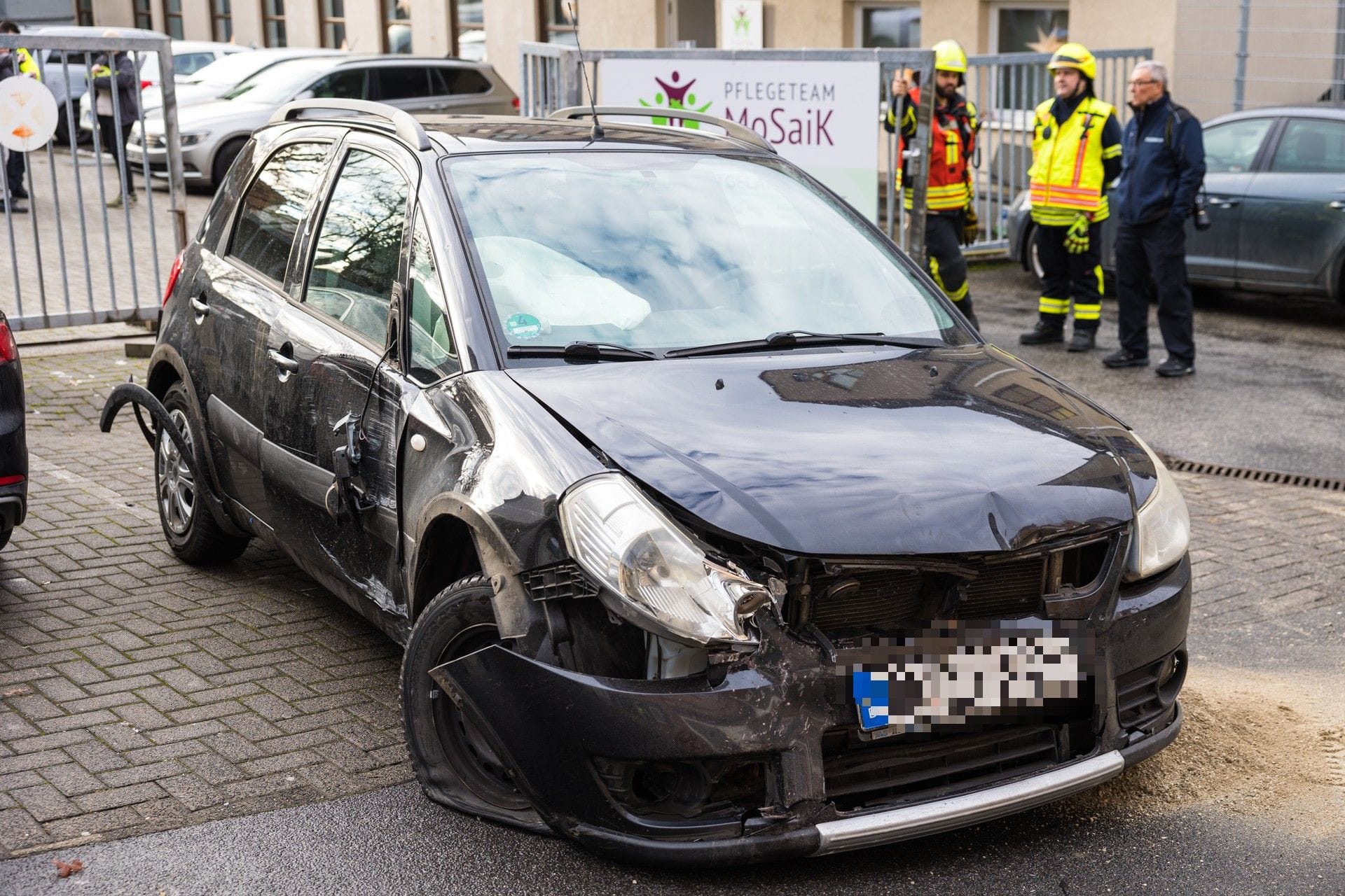 Das beschädigte Auto: Der Fahrer riss ein Stahltor aus der Verankerungen und fuhr gegen zwei Hauseingänge.