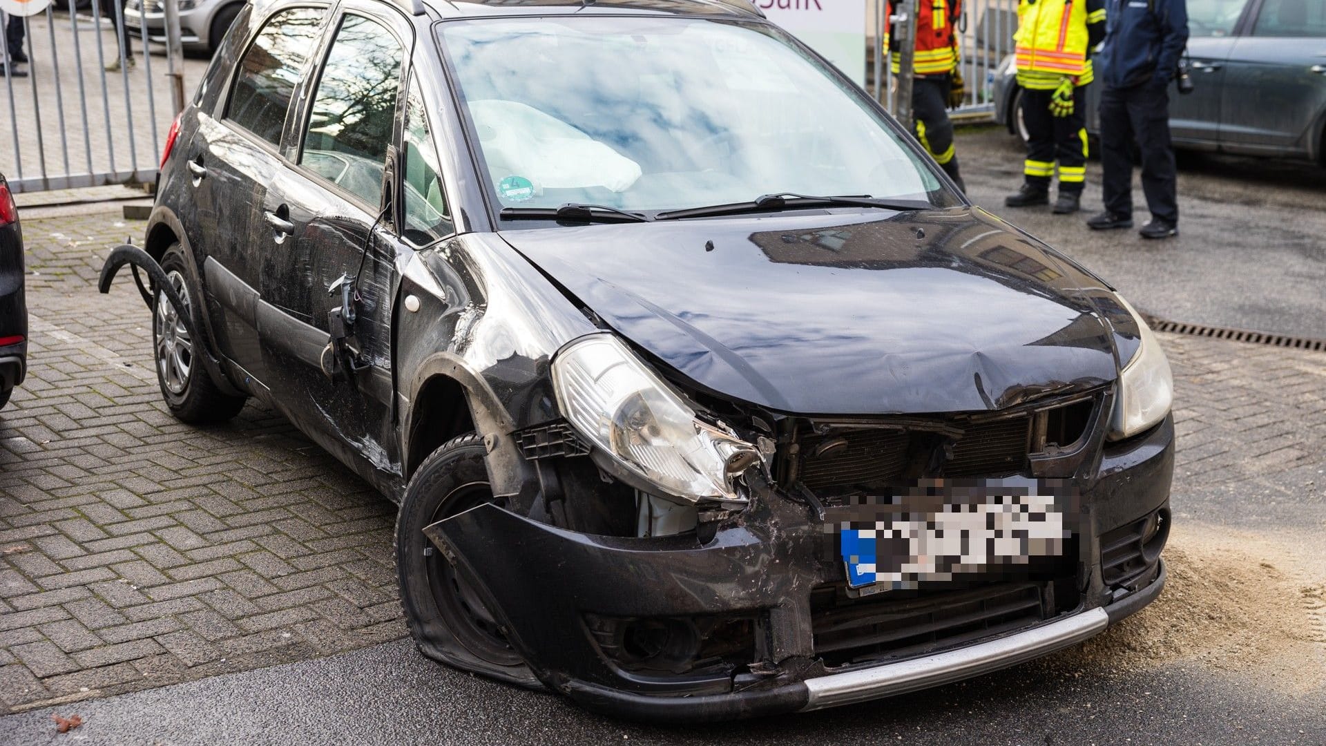 Das beschädigte Auto: Der Fahrer riss ein Stahltor aus der Verankerungen und fuhr gegen zwei Hauseingänge.