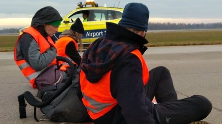 Klimaaktivisten kleben sich auf dem Rollfeld der Nordbahn auf dem Münchener Airport fest.