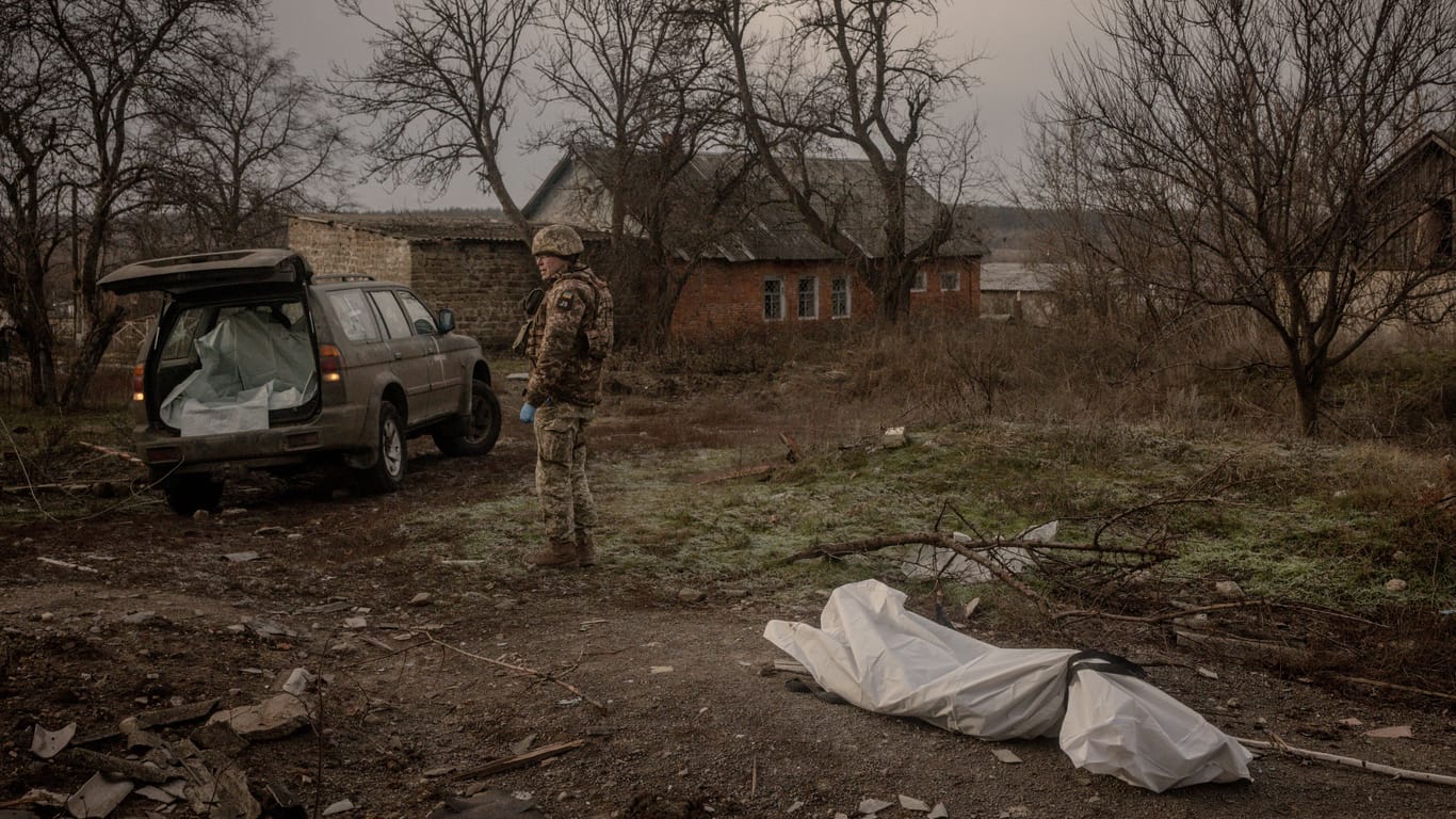 Ein ukrainischer Soldat birgt den Leichnam eines russischen Soldaten in der Nähe von Kupiansk.