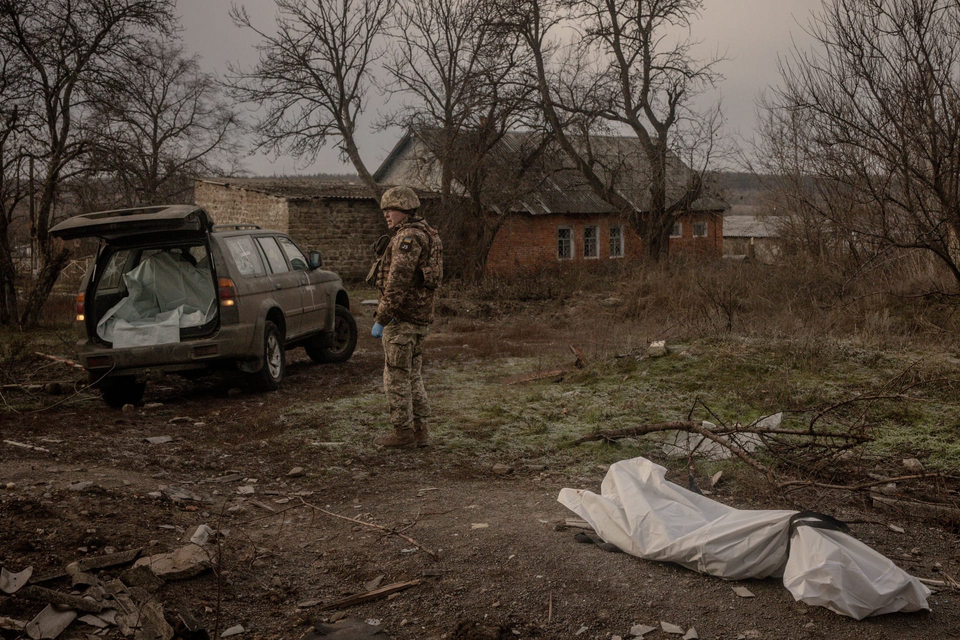 Ein ukrainischer Soldat birgt den Leichnam eines russischen Soldaten in der Nähe von Kupiansk.