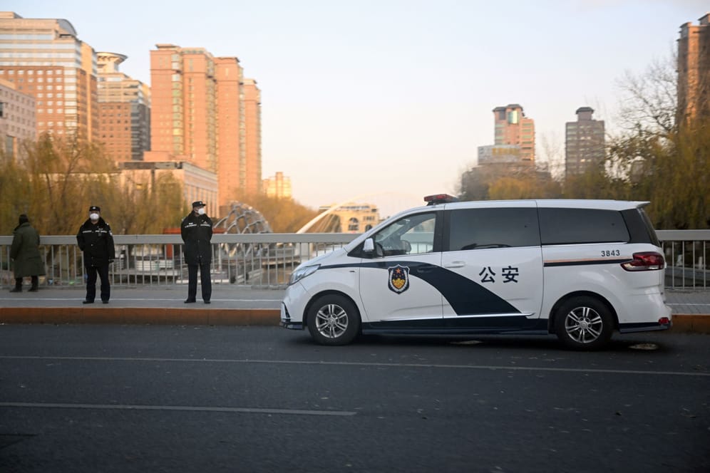 Polizisten in Peking überwachen die strengen Corona-Auflagen der Regierung.