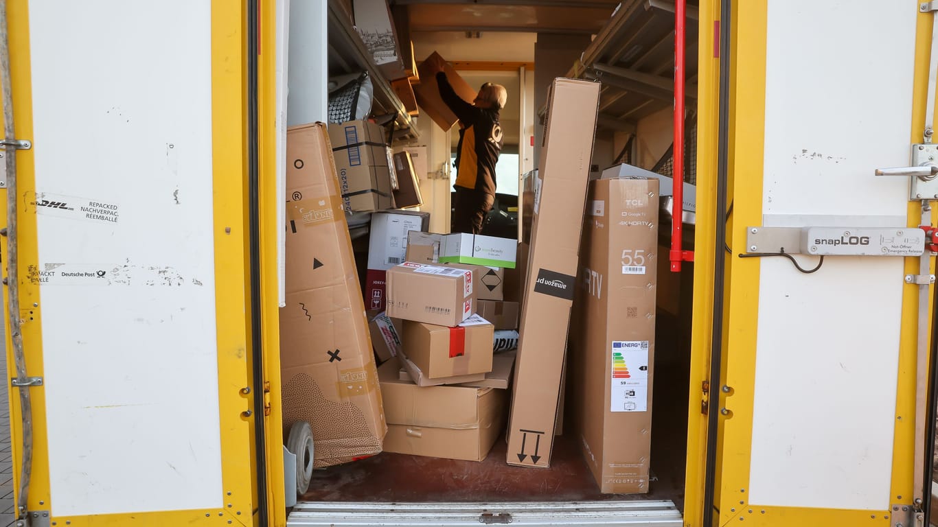 Eine Mitarbeiterin der Deutschen Post DHL belädt ihr Fahrzeug mit Päckchen und Paketen: Die Wochen vor Weihnachten bedeuten traditionell Hochbetrieb bei den Logistikunternehmen.