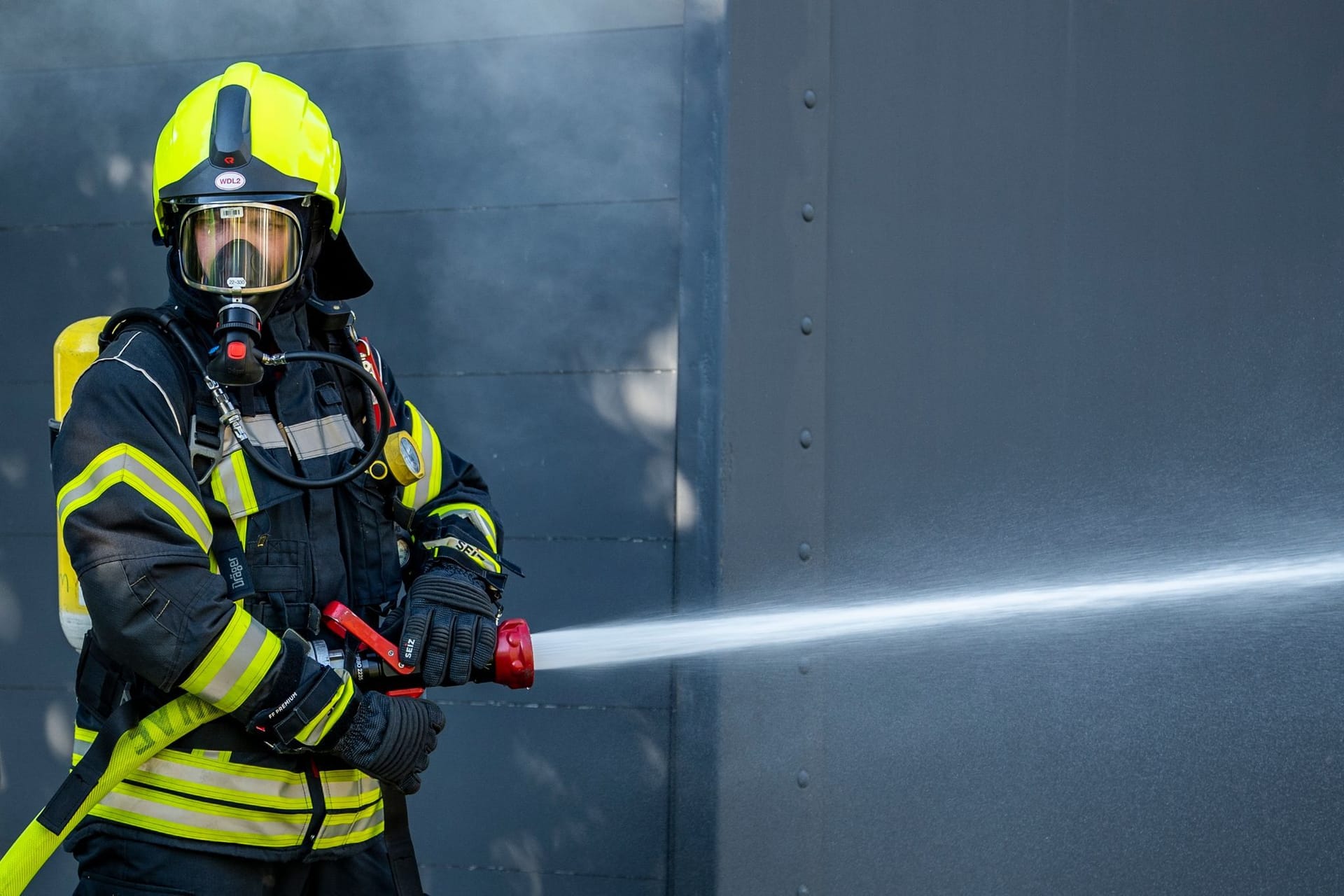 Ein Mitglied der Feuerwehr beim Löscheinsatz. (Symbolbild): Die Münchner Feuerwehr rückte am Abend vor Heiligabend zu einem Einsatz in Berg am Laim aus.