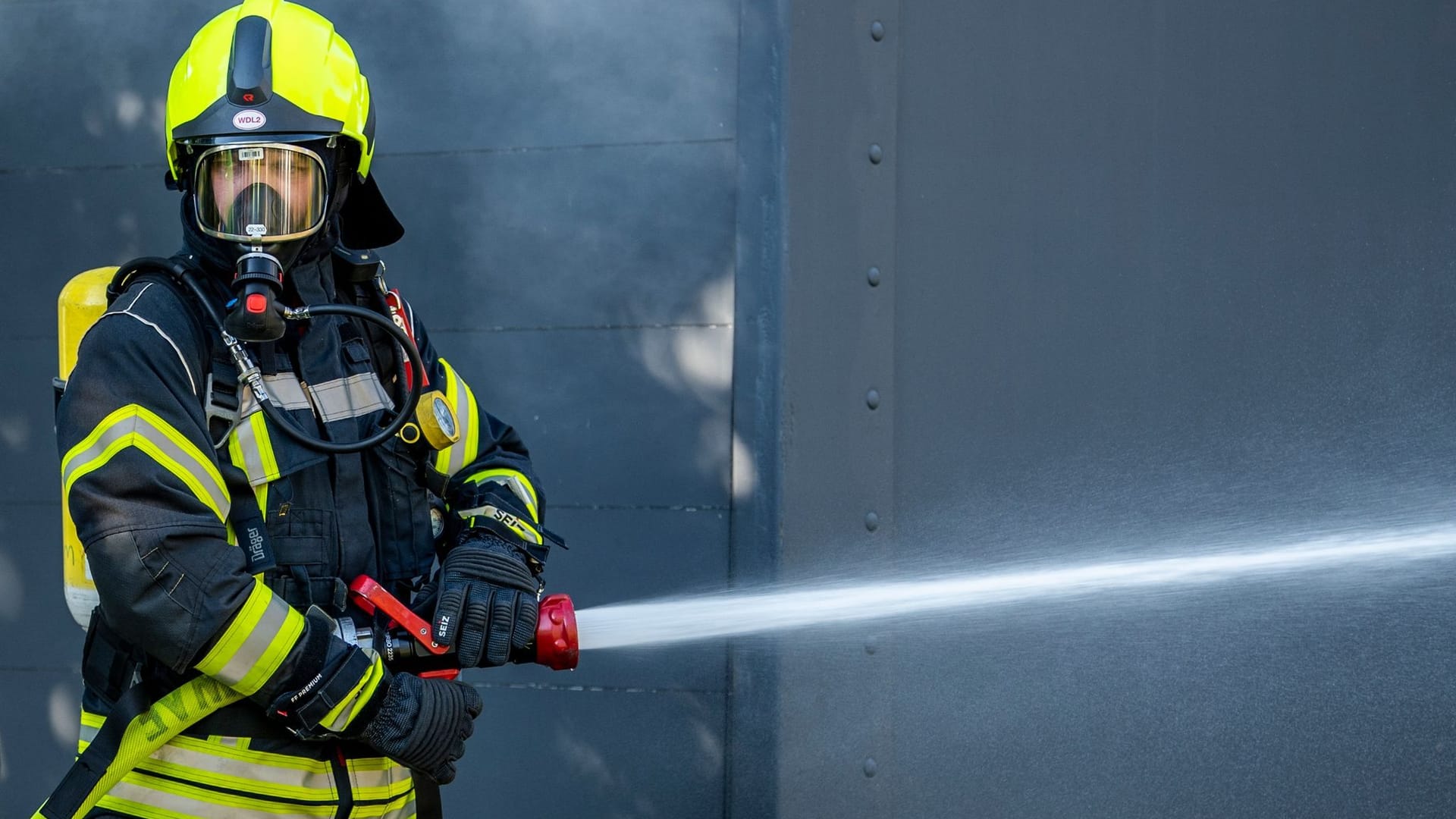 Ein Mitglied der Feuerwehr beim Löscheinsatz. (Symbolbild): Die Münchner Feuerwehr rückte am Abend vor Heiligabend zu einem Einsatz in Berg am Laim aus.